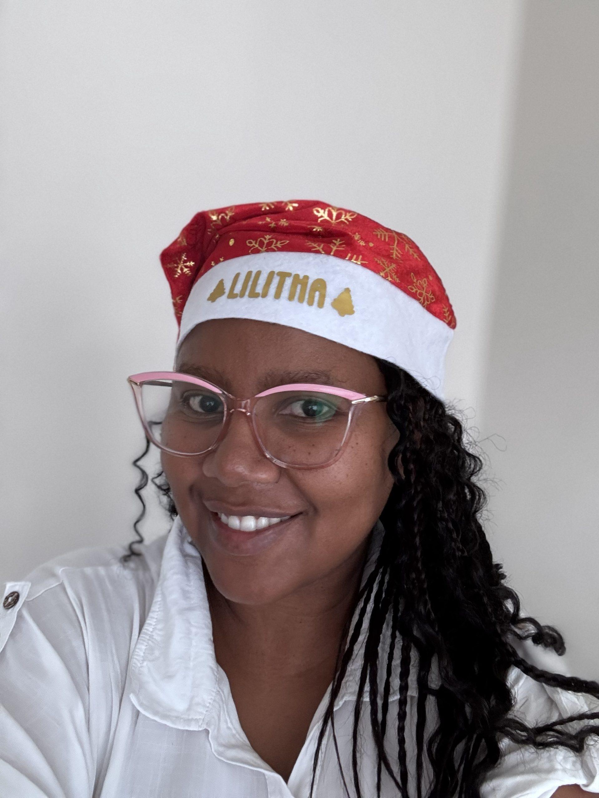 Red personalised Santa hat with gold snowflakes and custom name printed on rim.