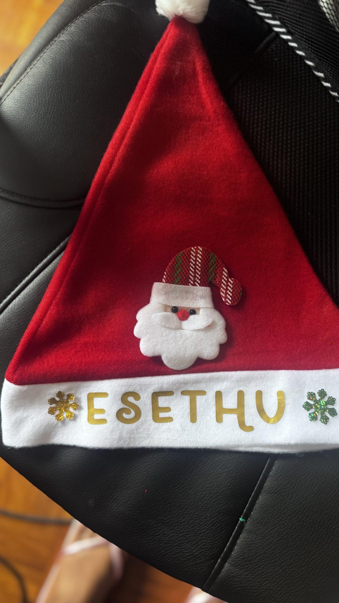 Red personalised Santa hat with custom name printed on rim.